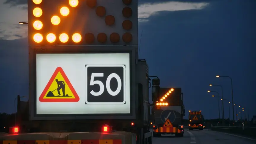 Skyddsbilar vid ett vägarbete. Skylten visar hastighet 50