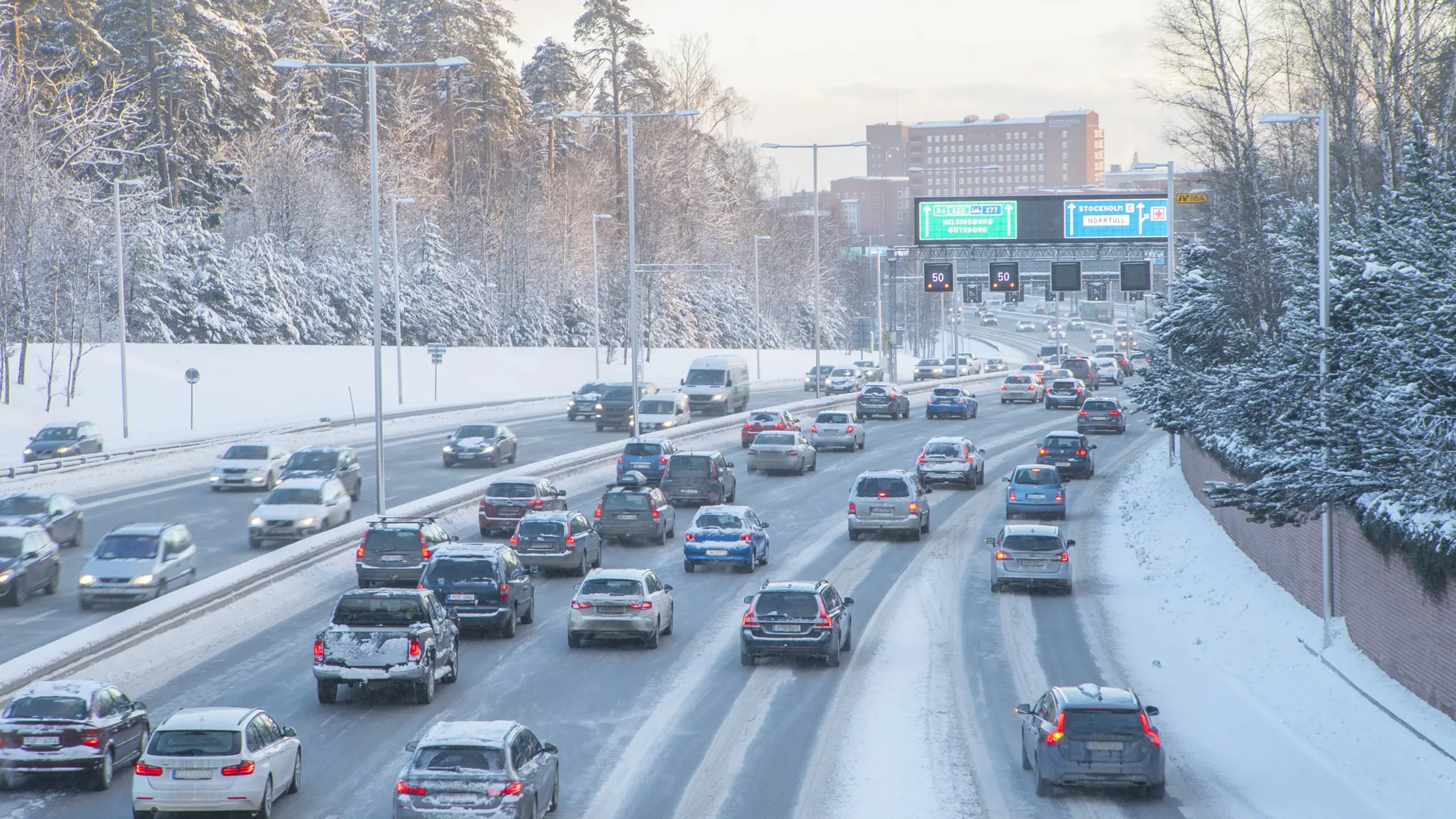 Trafik i ett vintrigt Stockholm i höjd med Hagaparken.