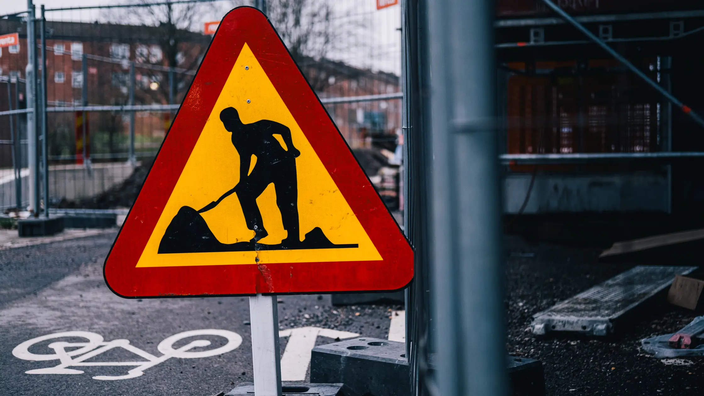 Vägarbetesskylt och staket i bakgrunden