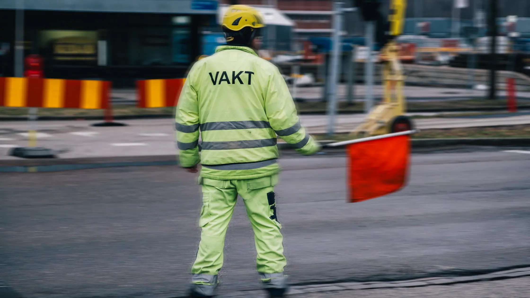 en flaggvakt ståendes vid ett vägarbete