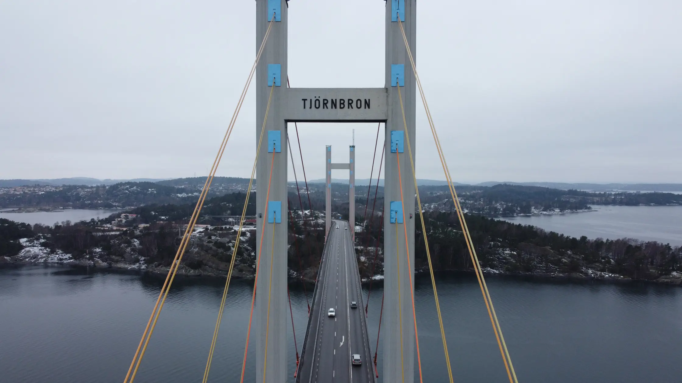 Drönarbild på Tjörnbron framifrån. Man ser skylten där det står Tjörnbron längst fram och även fem personbilar som kör på bron.