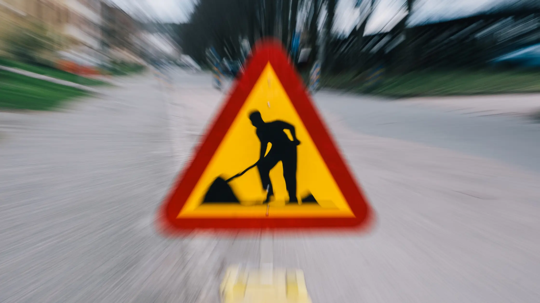 En vägarbetesskylt och blurrig bakgrund.