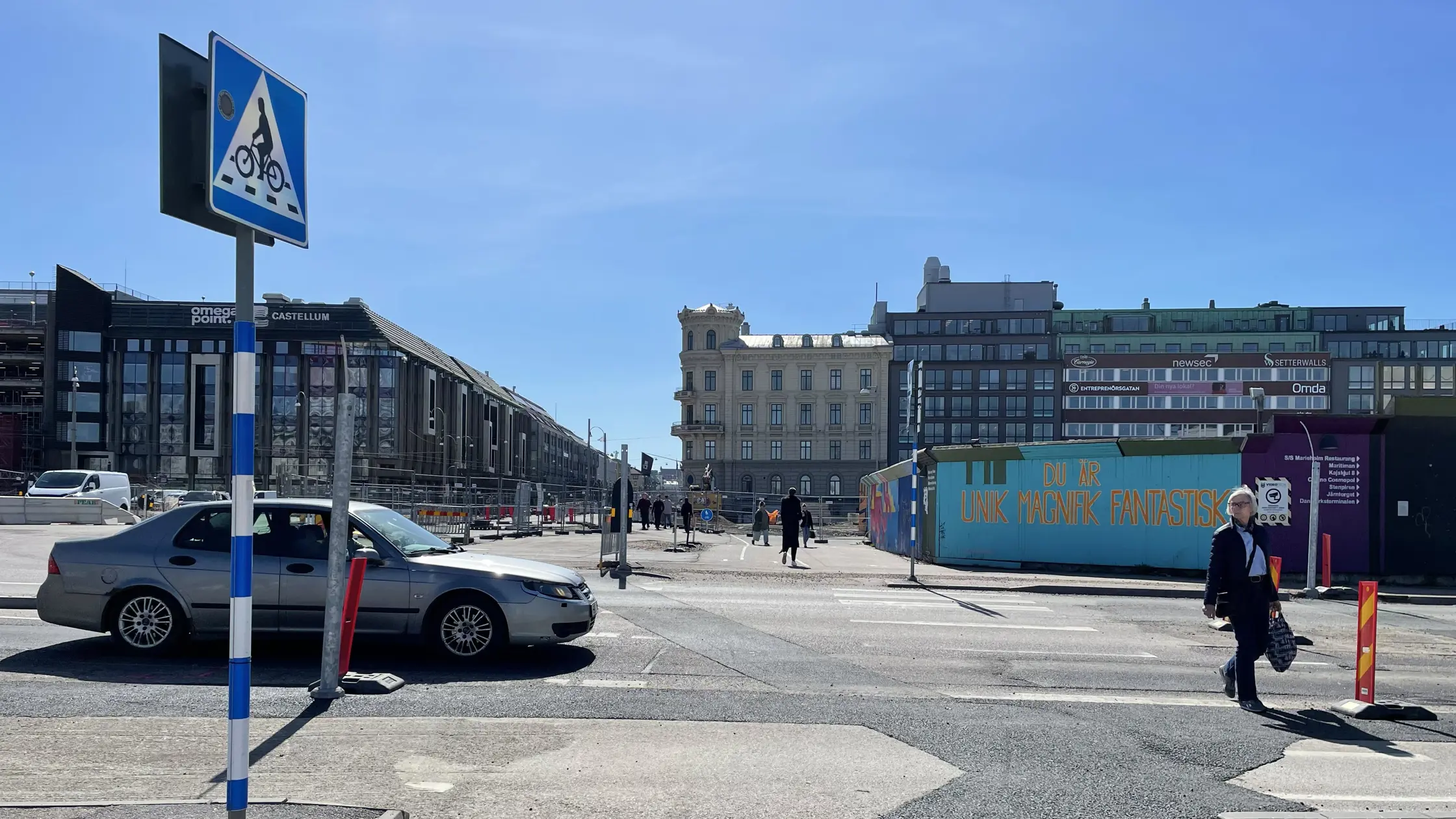 En kvinna går över den nya passagen vid Opergatan en bil väntar tålmodigt.