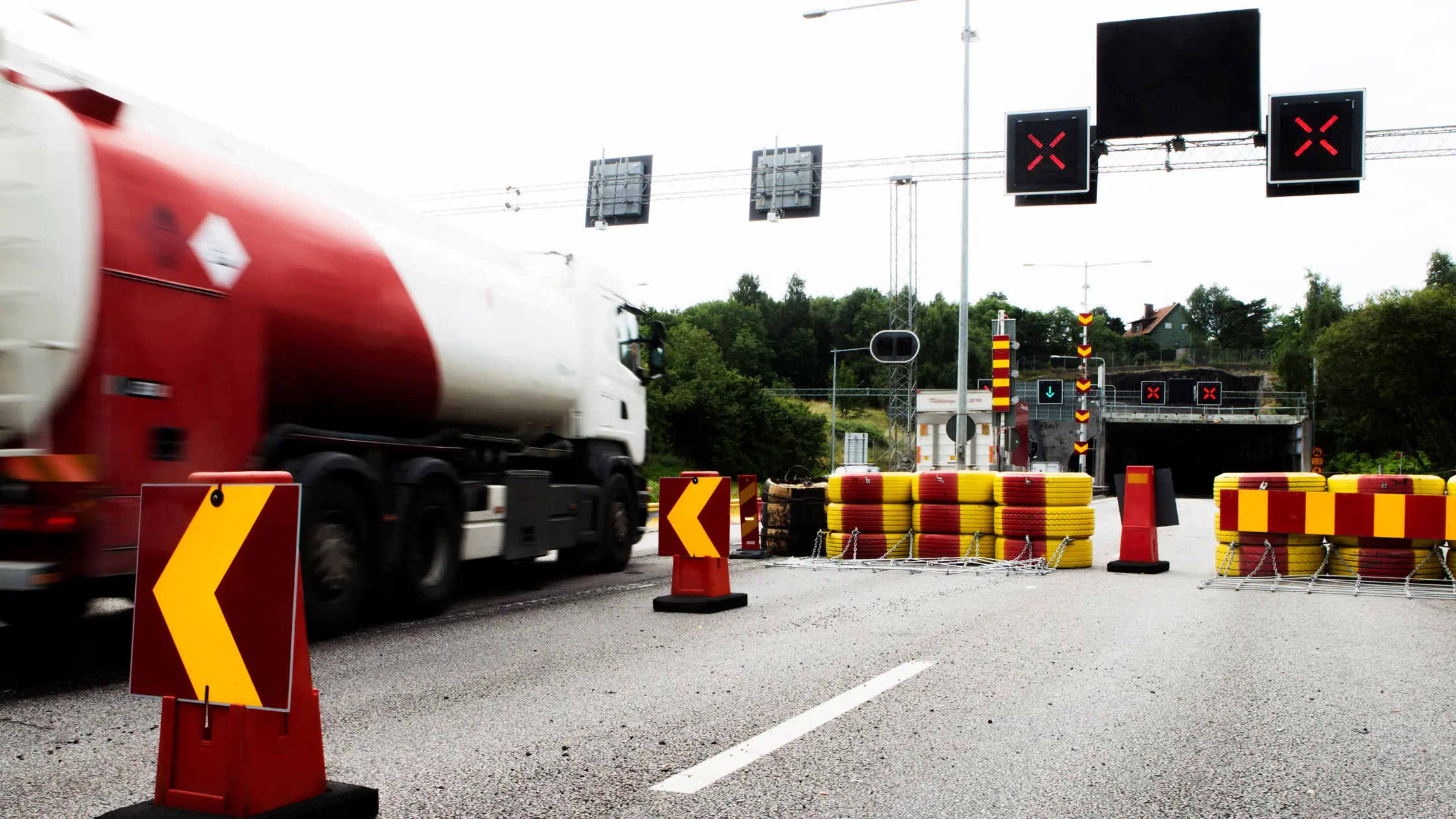 Vägen är avstängd röda kryss lyser över vägbanan en lastbil passerar i motsatt riktning.