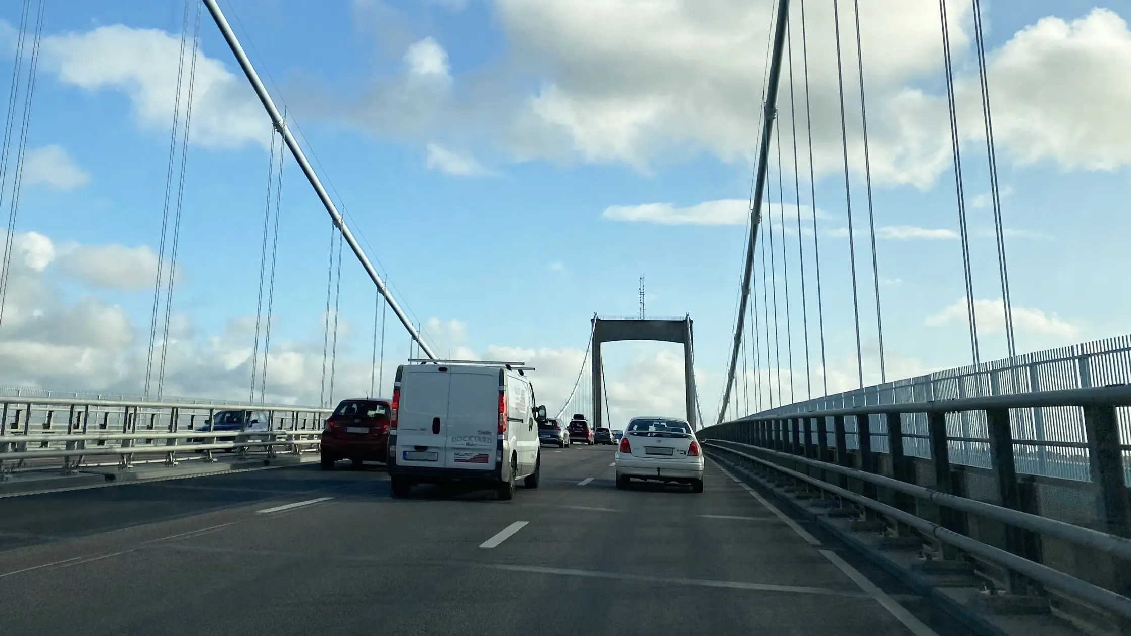 Fordonstrafik kör över Älvsborgsbron. Pylonerna syns i bakgrunden.