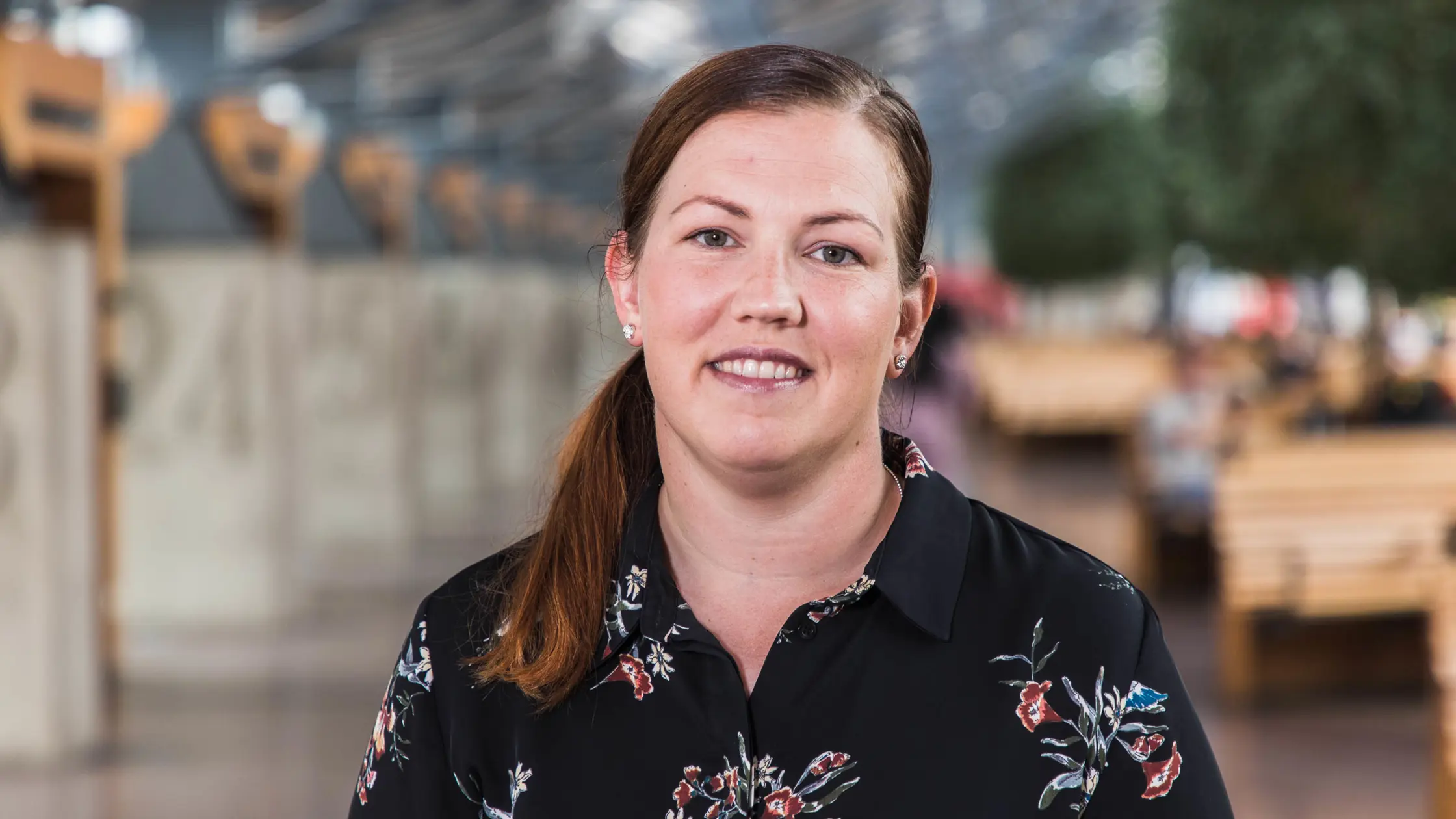 Anette Ekdahl, projektledare vid Västtrafik, porträtterad inne på Nils Ericsonsterminalen iklädd mörk blus med stora blommor på. 