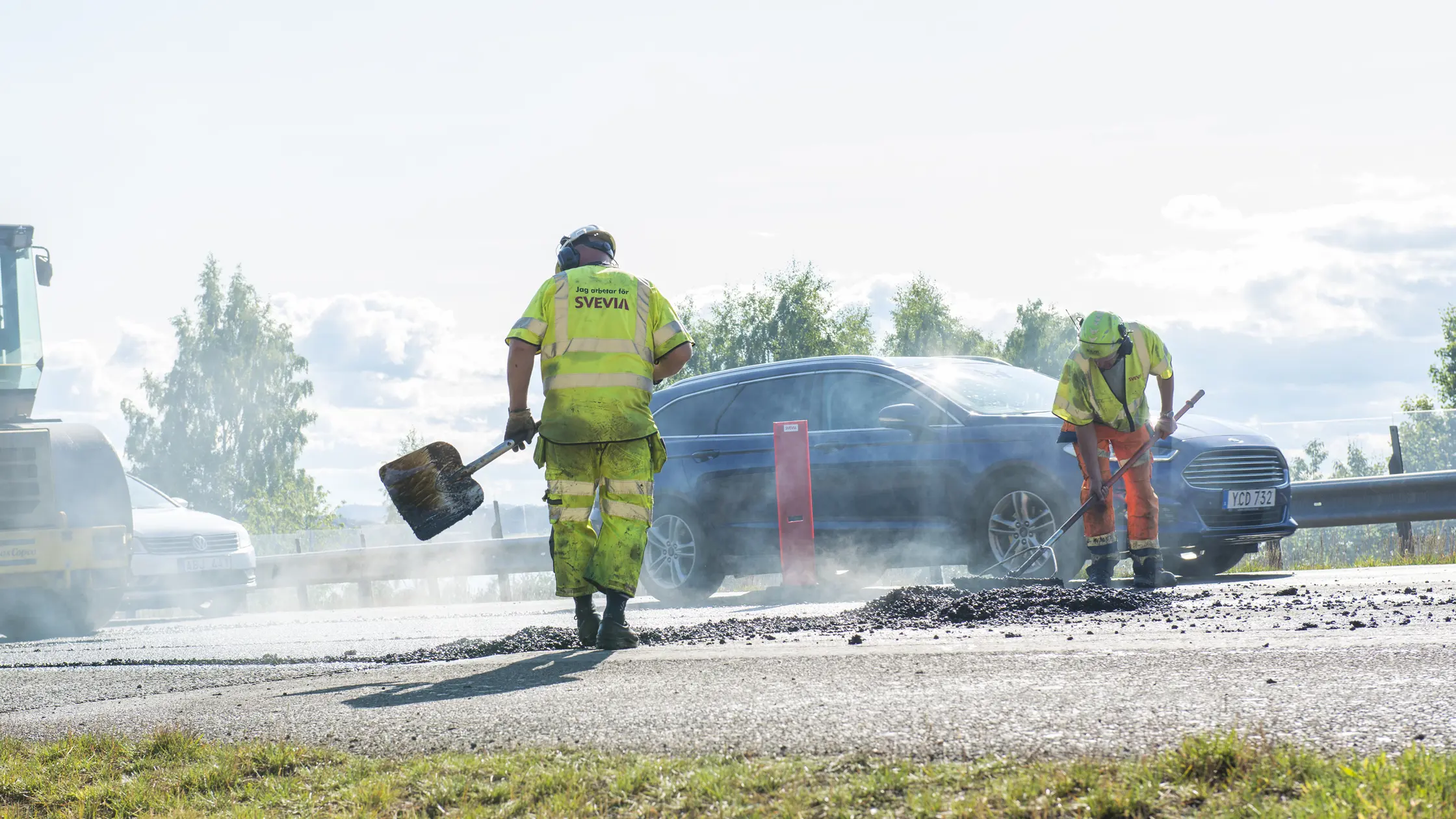 En vägarbetare syns vid ett beläggningsarbete.