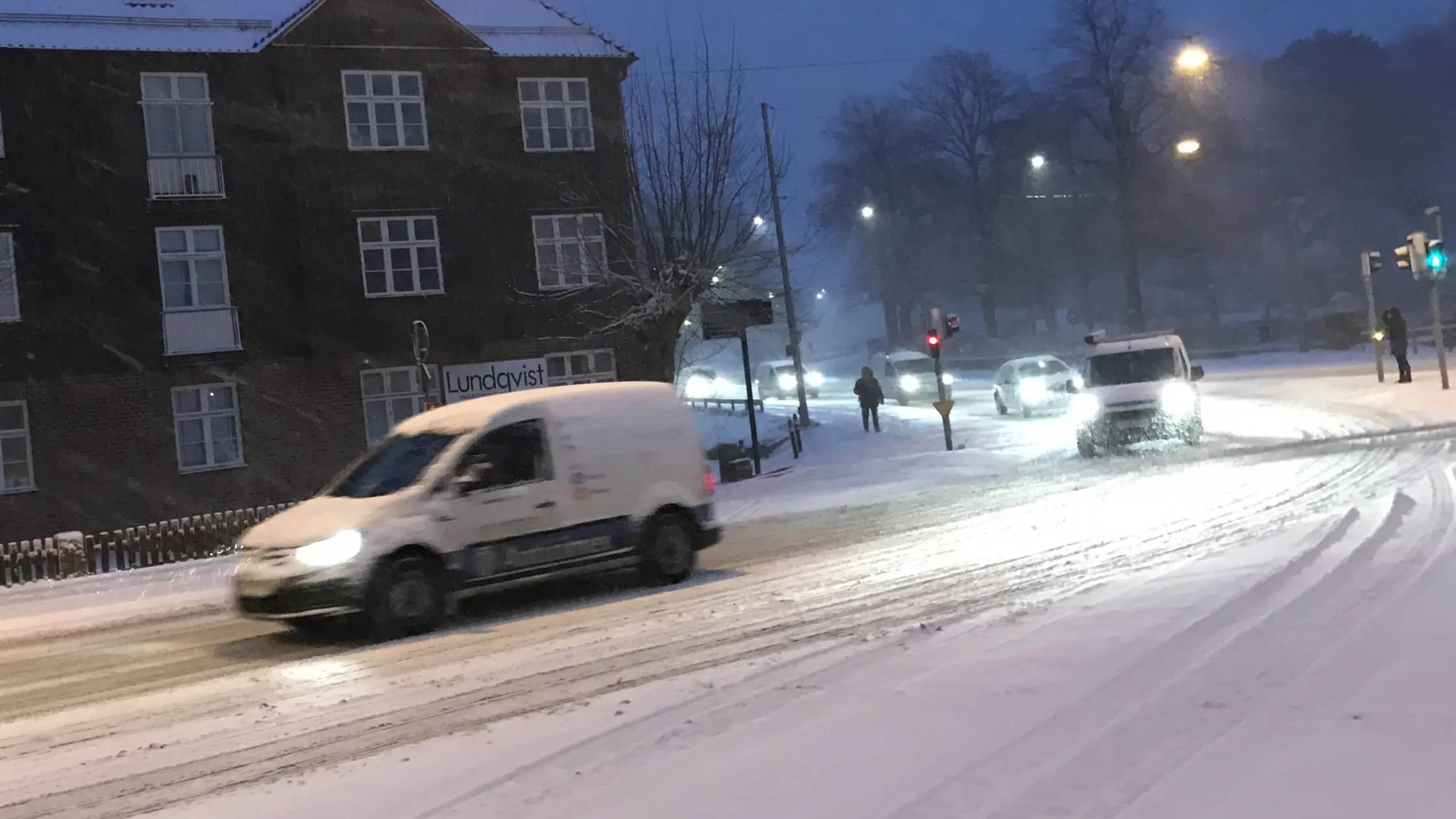 Två personbilar kör på snöiga kommunala vägar.