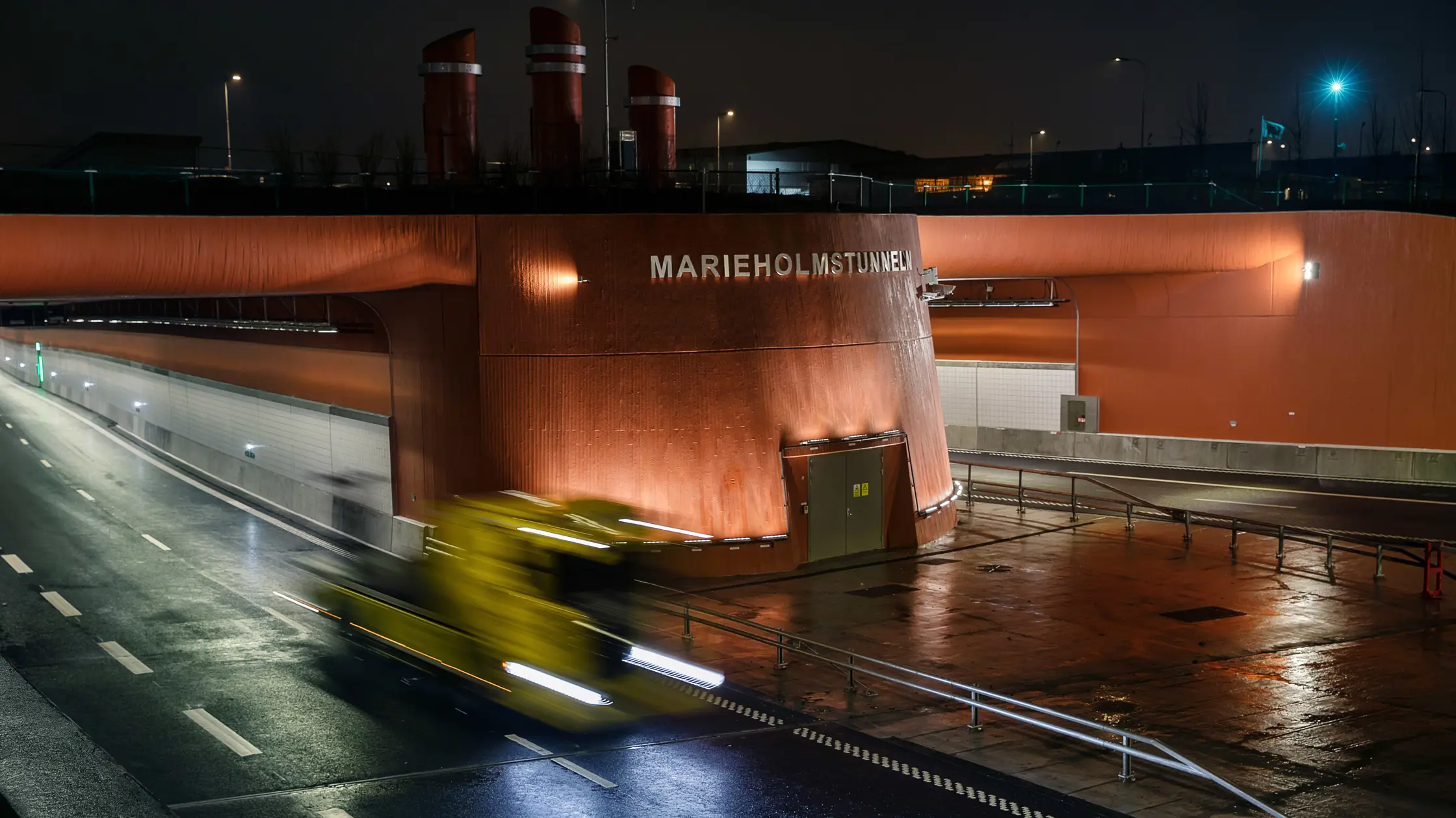 En ensam lastbil kör ut från Marieholmstunneln under en mörk regntung himmel