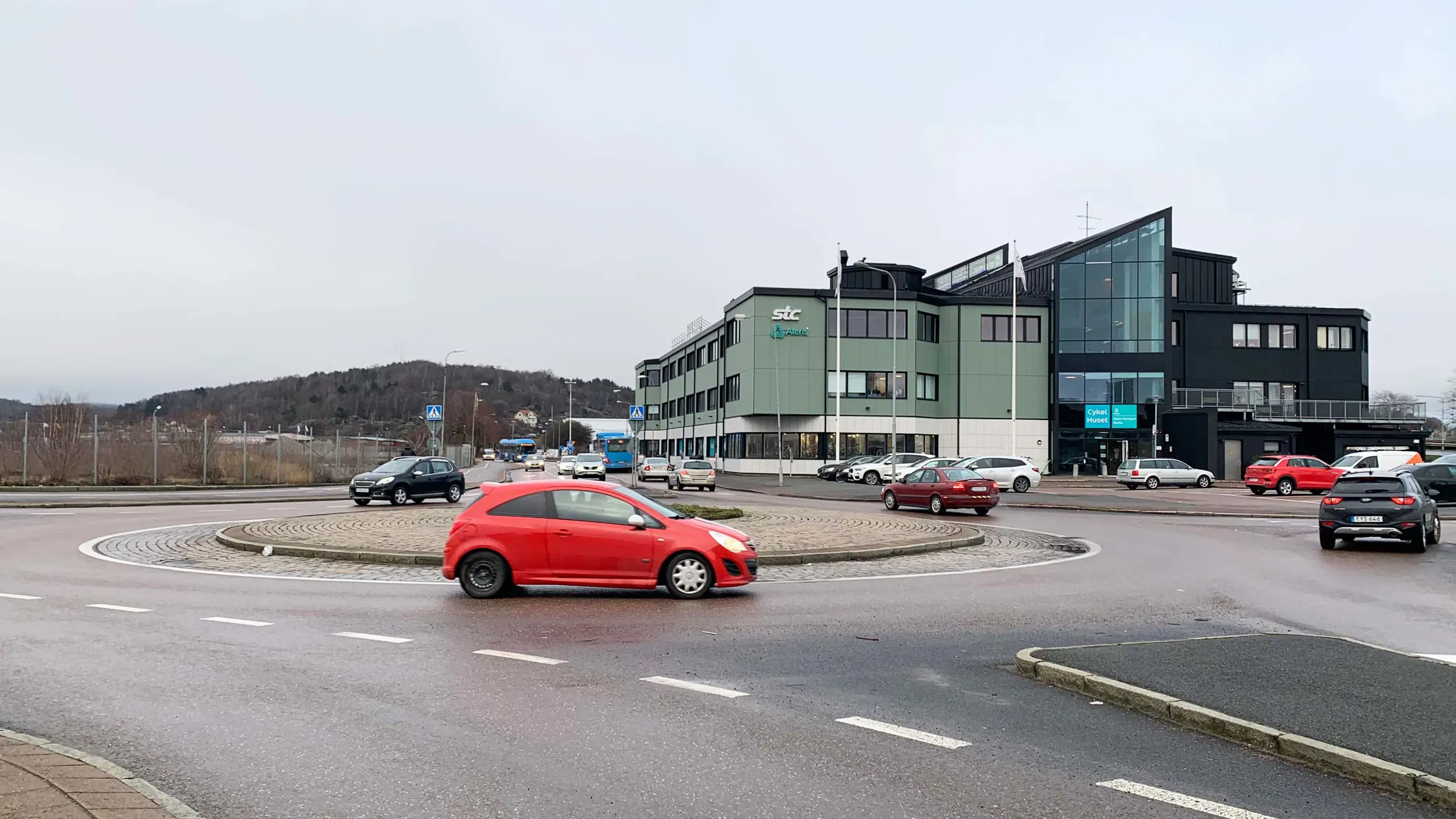 Rondellen vid korsningen Backavägen - Södra Deltavägen en röd bil kör just in i rondellen.