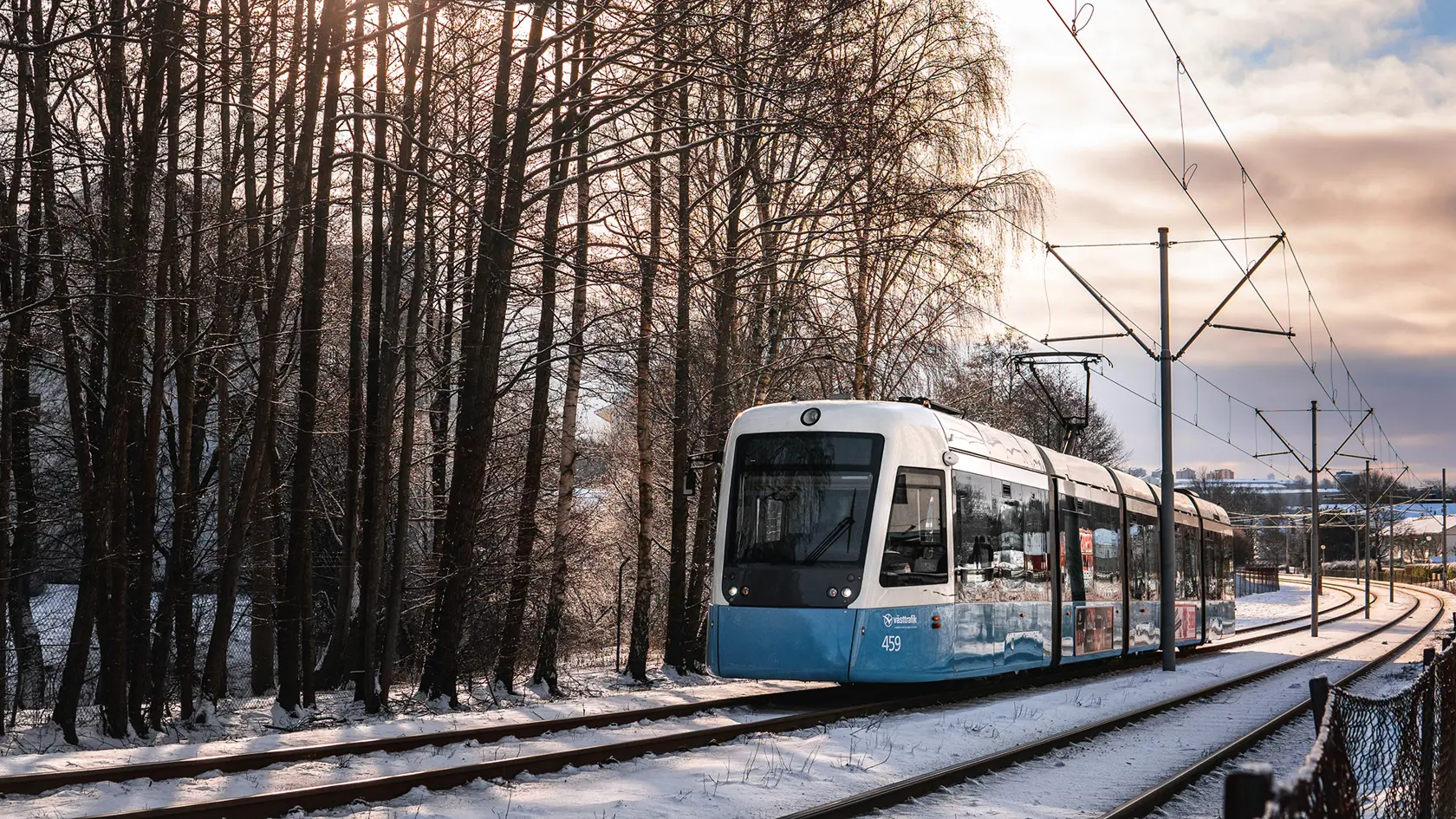 Spårvagn i rörelse i snölandskap.